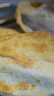 Lezzetli, fırında pişirilmiş deniz çerezi altın sarısı hamur işi ile kaplanmış lezzetli bir restoranda servis edilen lezzetli bir deniz ürünleri yemeğinin içindeki taze beyaz balığı göstermek için çatal ve bıçakla açılır..