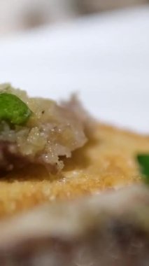 Kızarmış kemik iliği yanında kemik iliği hamuru sosu zengin ve lezzetli gurme yemekleri modern yemek deneyimi eşliğinde beyaz bir tabakta servis edilir..