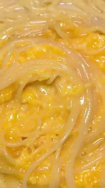 Spagetti pişiriyorum. Erişte yemeği. Şef sıcak vejetaryen tavasını fırında metal cımbızla karıştırıyor. Beyaz soslu lezzetli makarna. Yüksek kalite 4k görüntü