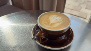 Bir el kaldırma ve bir kafeterya masasına dumanı tüten bir kahve fincanı yerleştirme hareketi yaşam tarzı, içecek reklamları veya rahatlama içeriği için idealdir. Yüksek kalite 4k görüntü