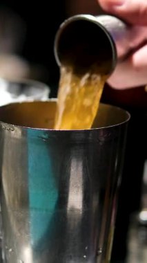 Profesyonel bir barmen ölçü kabına alkol doldurur. Bu da barın yakınındaki bir kulüpte kokteyl yapma işlemidir. Yüksek kalite 4k görüntü