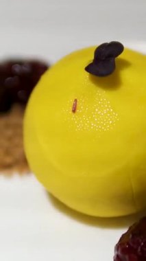 Güzel bir restoranda zarif bir şekilde servis edilen gurme tatlısında kare kremalı pasta, sanatsal süslerle, mutfak ve yemek sunumu kavramları için idealdir. Yüksek kalite 4k görüntü