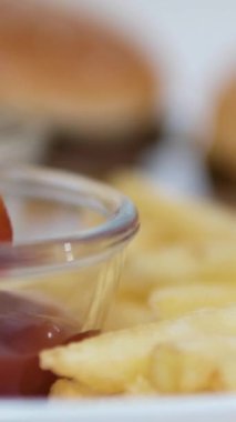 Lezzetli hamburger, büyük bir pirzola ve ketçaplı patates kızartması. Patates kızartmasını ketçapa batır.