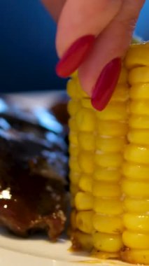 Pirzola, mısır ezmesi, tanınmayan erkek şefin dilimlenmiş biftek ve çam fıstığı ve mikroyeşille süslenmiş ızgara sebzeyle beyaz tabak göstermesi. Yüksek kalite 4k görüntü