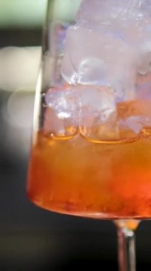 Parlak bir yaz kokteyli hazırlama süreci. İçinde portakal kabuğu özü de var. Barmen içkiye narenciye tazeliği vermek için kabuğu büker. Yüksek kalite 4k görüntü