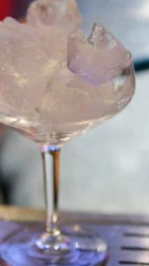 Boş bardağa buz koy. Buz küpleri boş şeffaf bardağa düşüyor. Taze bir içki yap. B sahnesi 4K. Ağır çekim. Yüksek kalite 4k görüntü