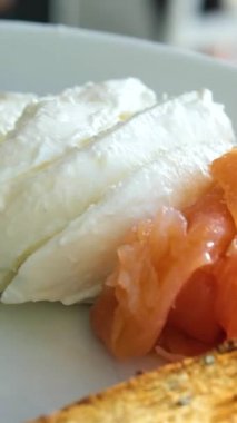 Ev yapımı simit sandviçi yapıyorum. Elleri krem peynir, somon, marul, vişneli domates, avokado ve salatalık soslu glütensiz simit. Sağlıklı .