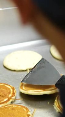 Sıcak ızgarada Kore Sokak Yemekleri Peynirli Ekmek. Mavi lateks eldiven giyen bir adam fırında krep çeviriyor.