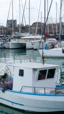 Catania Sicilya limanına yanaşmış tekne ve yatların huzurlu manzarası berrak mavi su güneş ışığı ve rahat Akdeniz havasıyla. Catania Sicilya İtalya 10.05.2025