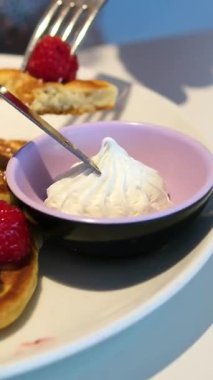 Doğu Avrupa mutfağında geleneksel yemek olarak da bilinen küçük krepler, taze böğürtlen, krema ve bir bardak portakal suyu ile servis ediliyor. Kahvaltıyı çatal ve bıçakla dikkatlice ye.