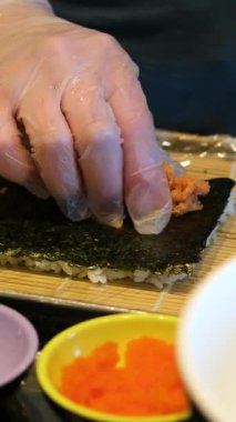 Suşi şefi, geleneksel Japon mutfağı ve yemekleri için hazırlıklar ve eller restoranda balık sarar. Mutfak, aşçılık sanatçısı ve deniz ürünleri, beslenme ve yemek için gurme ton balığı malzemeleri..