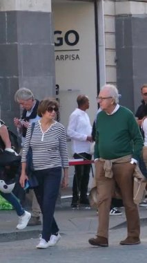 Turistler Catania Sicilya 'nın ana meydanında yürürken San Placido Kilisesi sakinleri de dahil olmak üzere tarihi yerleri çevrelediler. Şehir yaşamının hareketli sokaklarının tadını çıkarıyorlar. İtalyan atmosferi Catania Sicania İtalya 10.05.2025