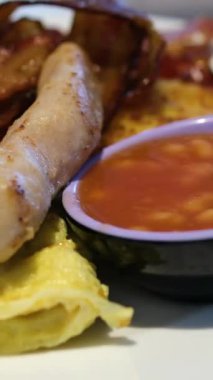 Geleneksel İngiliz kahvaltısı. Ulusal İngiliz mutfağı, domuz pastırması ve sosisli sahanda yumurta, tabakta tost. Amerikan barı ya da... Yüksek kalite 4k görüntü