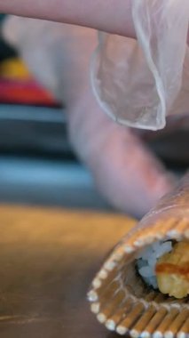 Suşi şefi, geleneksel Japon mutfağı ve yemekleri için hazırlıklar ve eller restoranda balık sarar. Mutfak, aşçılık sanatçısı ve deniz ürünleri, beslenme ve yemek için gurme ton balığı malzemeleri..