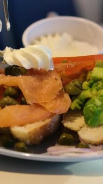 Tost üzerine somon dilimleri, şefin eli avakado ekmeğine çavdar ekmeği ile balık koyar. Yüksek kalite 4k görüntü