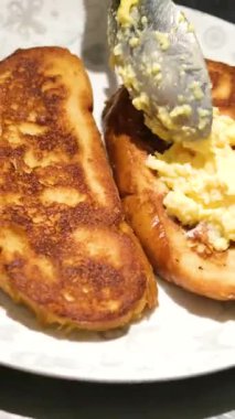 Peynirleri yumurtanın içinde pişmiş sandviçle eritiyoruz. Kahvaltıda peynirli tost. Yiyecekler. Yüksek kalite 4k görüntü