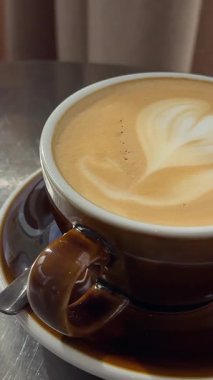 Bir el kaldırma ve bir kafeterya masasına dumanı tüten bir kahve fincanı yerleştirme hareketi yaşam tarzı, içecek reklamları veya rahatlama içeriği için idealdir. Yüksek kalite 4k görüntü