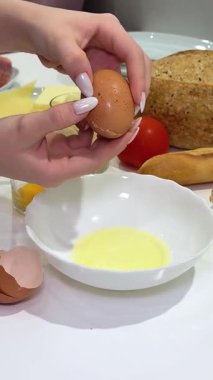 Mutfaktaki yumurta kavanozunu elle kıran şefin yumurta sarısını dök. Fırında ekmek pişirme işlemi. Modern Ev Mutfağı Masası 'nda vejetaryen yemeği pişirmek. Lezzetli Avrupa Yemekleri.