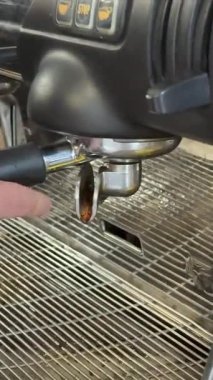 Kahve makinesinin espresso demlenirken, dokuları ve zengin renkleri ortaya çıkarırken, kafein hazırlığının işçiliğini ön plana çıkarırken detaylı detaylarını yakalar. Yüksek kalite 4k görüntü