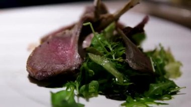 Pembe sos kuzu pirzolasına döküldü. Salata ve sarı şalgam ile birlikte mavi havluya. - Evet. Kızarmış kuzu salatası.