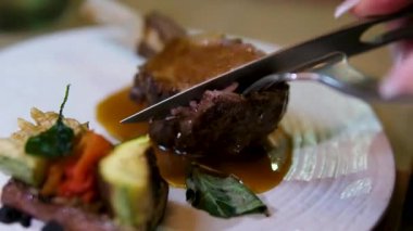 Lüks restoranda Asyalı bir kadın tarafından bıçaklanmış biftek. Sağlıklı beslenme ve beslenme konsepti. Yüksek kalite 4k görüntü