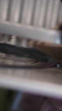 Kafe veya restoran mutfağındaki metal et ve sosis dilimleme makinesinin ayrıntıları profesyonel yemek hazırlama ve endüstriyel mutfak ekipmanlarını yansıtıyor. Dikey. Yüksek kalite 4k görüntü