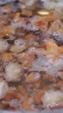 Kaynayan domuz yağının yakın çekimi. Yağlı kabarcıkların ve cızırtıların çiğ ve kırsal pişirme sürecini yakalayışını izleyin. Haşlanmış domuz yağı. Yüksek kalite 4k görüntü