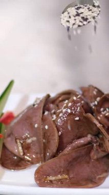 Sığır dilinin üzerine susam tohumu serpin. Ev yapımı leziz sığır eti salatası. Yüksek kalite 4k görüntü