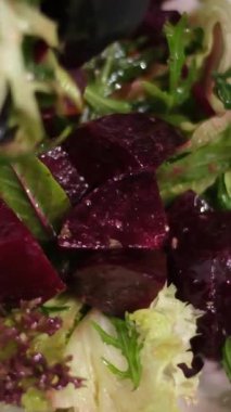 Pancar ve portakallı bir salata hazırlama işlemi, demir bir kase ekle, karıştır, tabağa koy. Yüksek kalite 4k görüntü