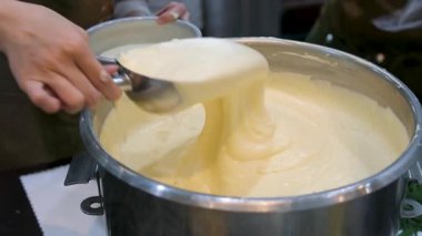 Kek hamuru pişirmek için metal bir tavada hazırlanıyor. Kremalı sarı hamur pürüzsüz ve kalın, pişirmeye hazır. Yüksek kalite 4k görüntü