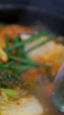 Fesleğen yapraklarıyla süslenmiş deniz ürünleri ve masada beyaz tabakta kiraz domatesli domates çorbası. Midye, kabuk ve tofu peynirli deniz ürünleri çorbası.