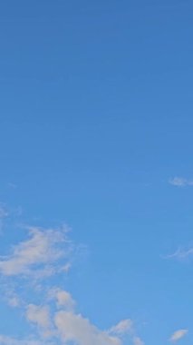 Gökyüzündeki yumuşak mavi bulutlar arasından yeşil bir alana iniyor. Yağmurdan sonra küçük bir gökkuşağı ortaya çıkıyor. Huzurlu doğal manzarayı ve huzurlu manzarayı gösteriyor.