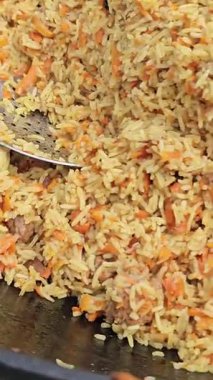 Doğada bir kazanda geleneksel doğu pilavı pişirmek. Yemek pişirmek. Aşçı pilav pişirir. Kazanda pilav