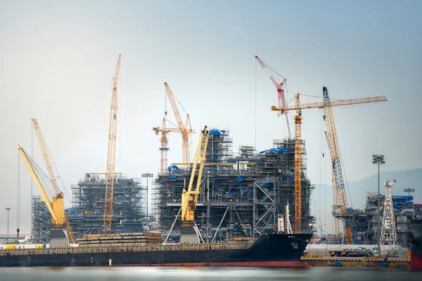 Raffinerie de pétrole de construction au port avec grue de travail et transport de gros bateaux, chantier . — Photo
