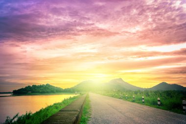 Büyük gölden geçen uzun yol, göl üzerinde dramatik gün batımı.