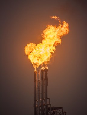İşaret fişeği yığını, yanan petrol gaz patlaması bir büyük petrol rafinerisi, arka plan.