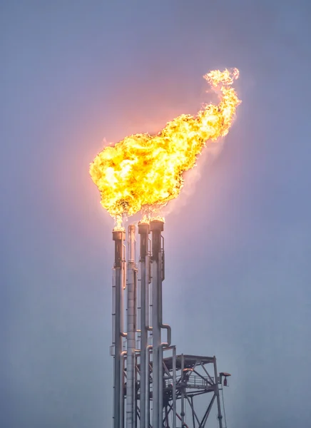 Apilamiento de bengalas, quema de bengalas de gas en una gran refinería de petróleo, fondo abstracto — Foto de Stock