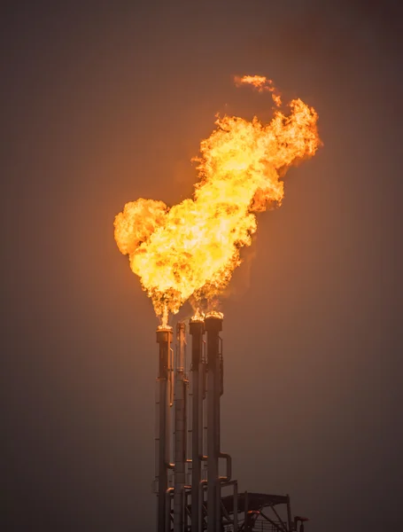 Flare stack, Burning oil gas flare in a large oil refinery, Abstract Background.