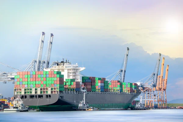 Containerschifffahrt, logistischer Import Exporthintergrund, Frachtschiffcontainer, Kranverladecontainer im Frachtschiff in der Abenddämmerung, Containerfrachtschiff mit funktionierender Kranbrücke in der Abenddämmerung — Stockfoto