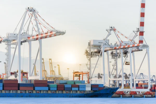Container vrachtschip met poorten kraan bridge in haven voor logistieke importeren exportindustrie achtergrond en vervoer. — Stockfoto