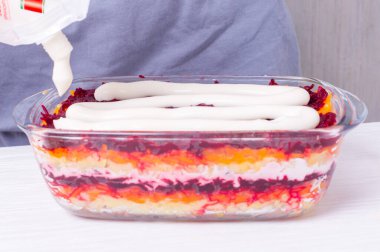 Rus geleneksel yeni yıl aperatiflerinin adım adım hazırlanması - haşlanmış sebze ve mayonez katmanlarının altında ringa balığı (shuba). 11 adımın 10 'u - aperatifin ikinci seviyesine yayılmış mayonez.,