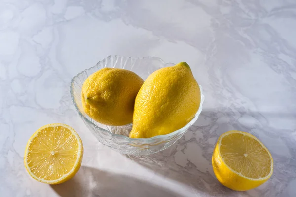 Dilimlenmiş Bütün Limonlar Beyaz Bir Masada Cam Bir Kasede Vitamini — Stok fotoğraf