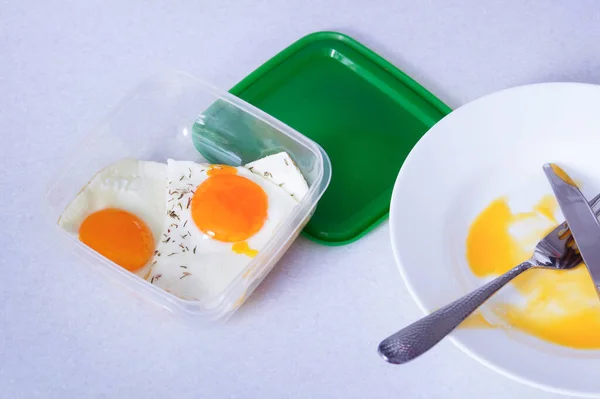 scrambled eggs in a plastic container. leftover food for the future, food saving, reasonable consumption