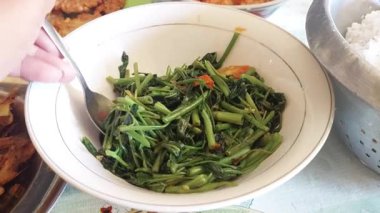 Karıştırılmış su ıspanağı masada bir kasede pişiyor.