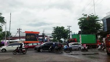 Makassar, Endonezya, 28 Kasım 2025. Yoğun bir şehir kavşağı her yöne giden araçlarla doludur..