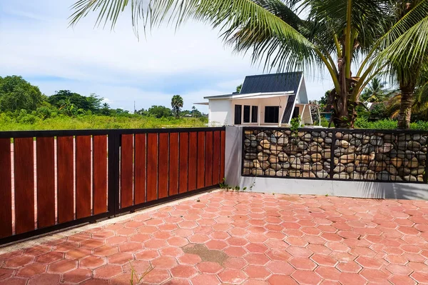 Çitin yanında küçük bir villa görülebilir..