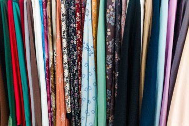 Renkli kumaşın dokusu düzgünce asılmış.