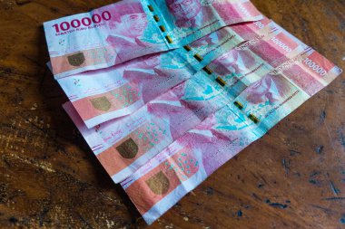 100 bin rupiah bayram parası, Endonezya Cumhuriyeti para birimi, ahşap bir masa üzerinde.