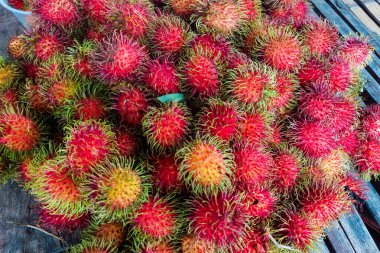 Ahşap zemine yığılmış kırmızı Rambutan