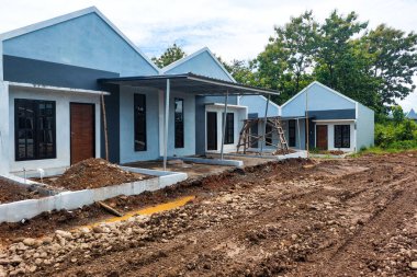 Çamurlu yolu olan bir dizi yeni yapılmış kalıcı eve benziyor..